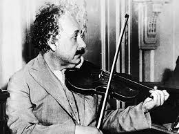 A man playing the violin in an old photo.